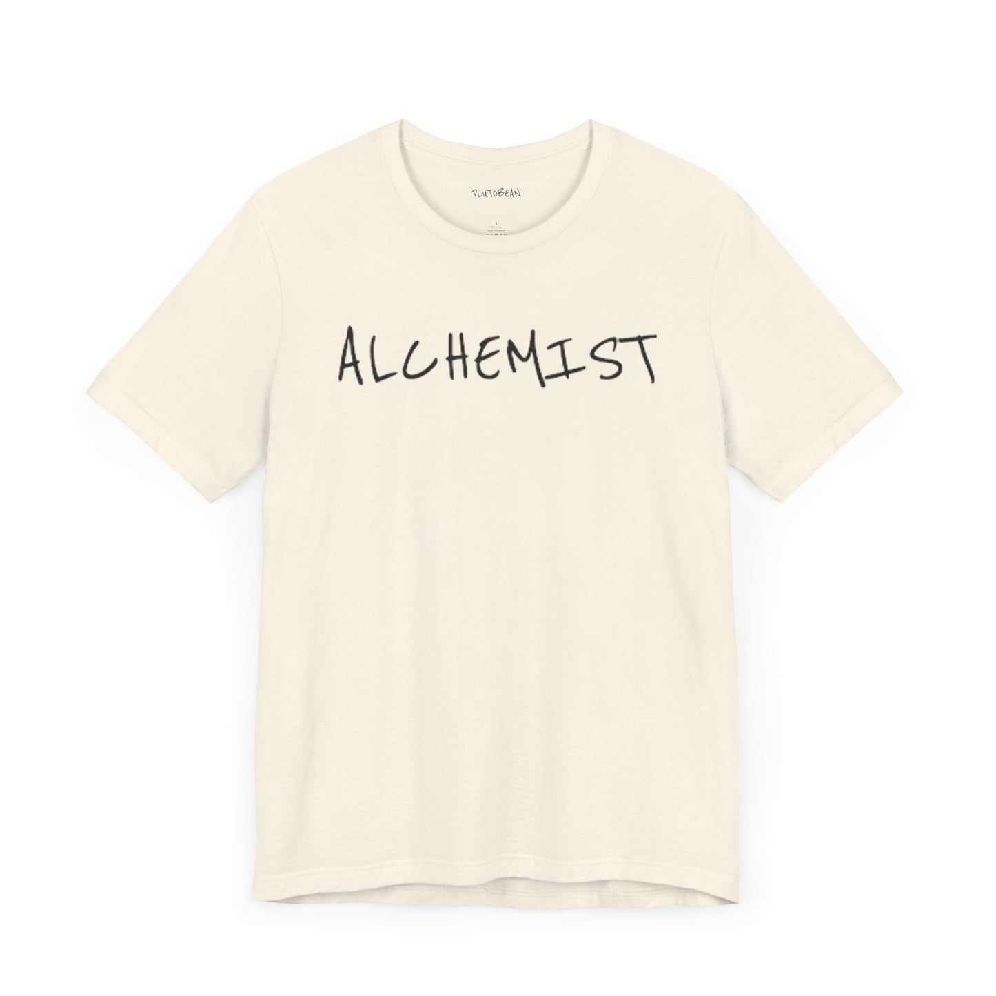 Natural t-shirt with handwritten black “ALCHEMIST” text across the chest