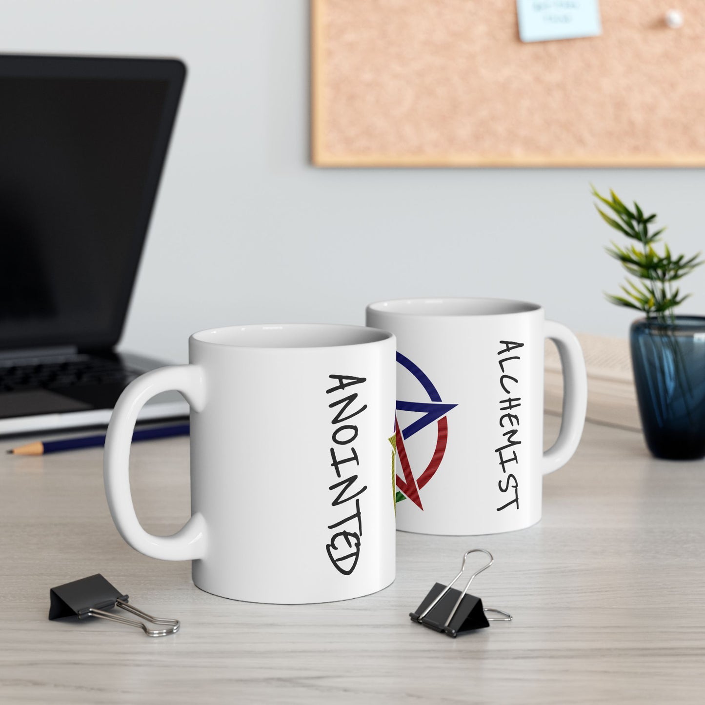 Two white mugs with text on a desk, one featuring a peace symbol.